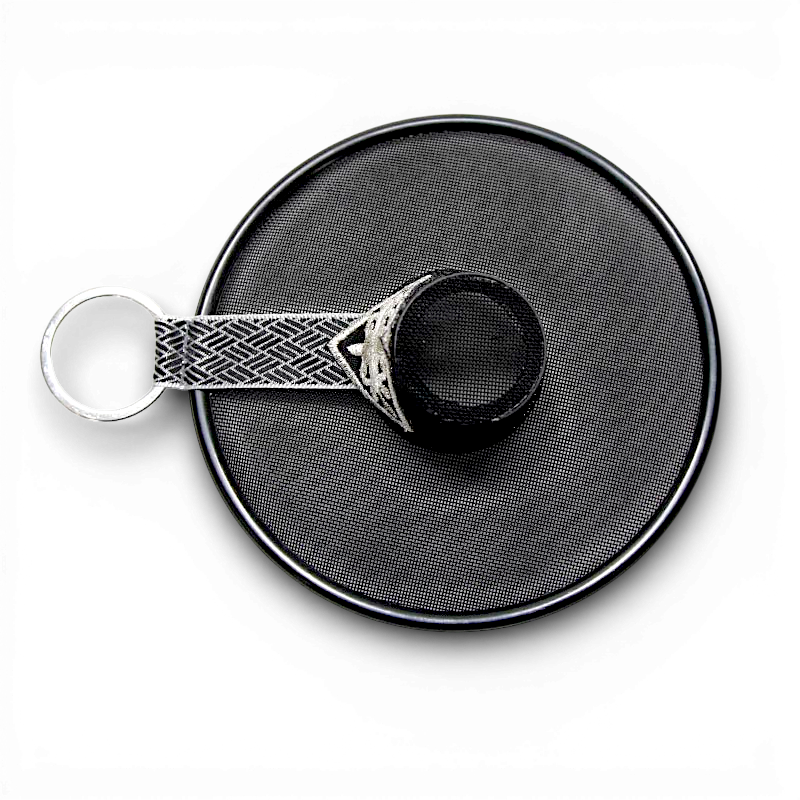 검은색 망사 천과 금속 테를 사용한 갓 모양 장식, 흑백 기하학 문양 리본이 연결된 키링.