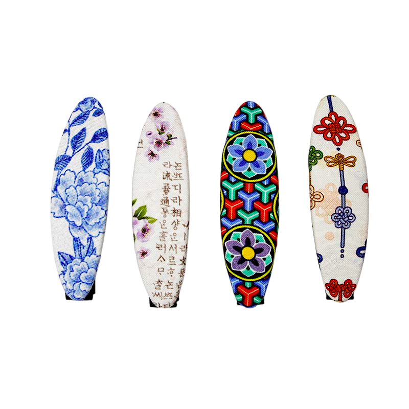 비단 재질 위에 청화 매화문, 한글 서체와 매난국죽, 다채로운 전통 기하·연꽃문, 색실 노리개 문양을 담은 작은 집게핀 세트.