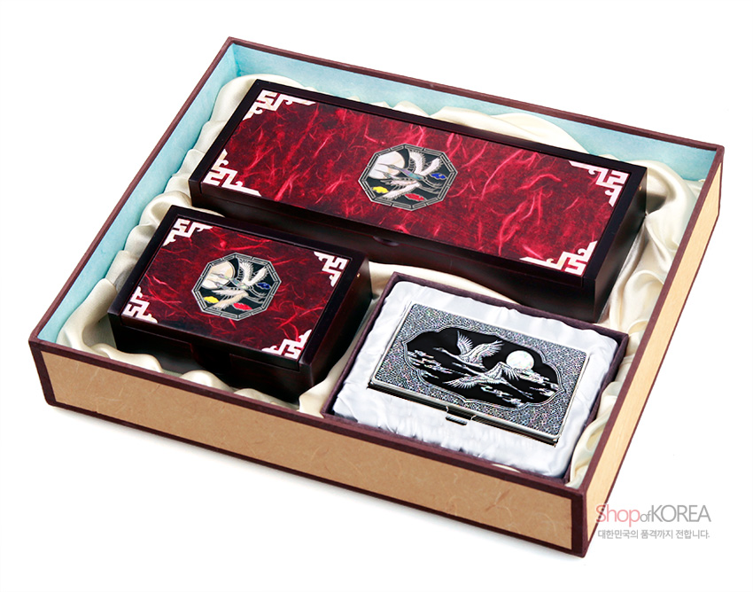 [텍스트: shopofKOREA 대한민국의 품격까지 전합니다.] 붉은 한지 위 백색 전통 문양과 운학 자개 상감이 돋보이는 자동함과 흑색 바탕 자개 운학·월광 문양 명함 케이스 세트 이미지 설명