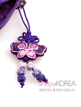 [텍스트: Shop of KOREA 대한민국의 품격까지 전합니다.] 자색 비단 끈과 전통 매듭으로 연결된 나비 자수 장식, 아래로 이어진 옅은 보라색 매듭 술 장식 모습
