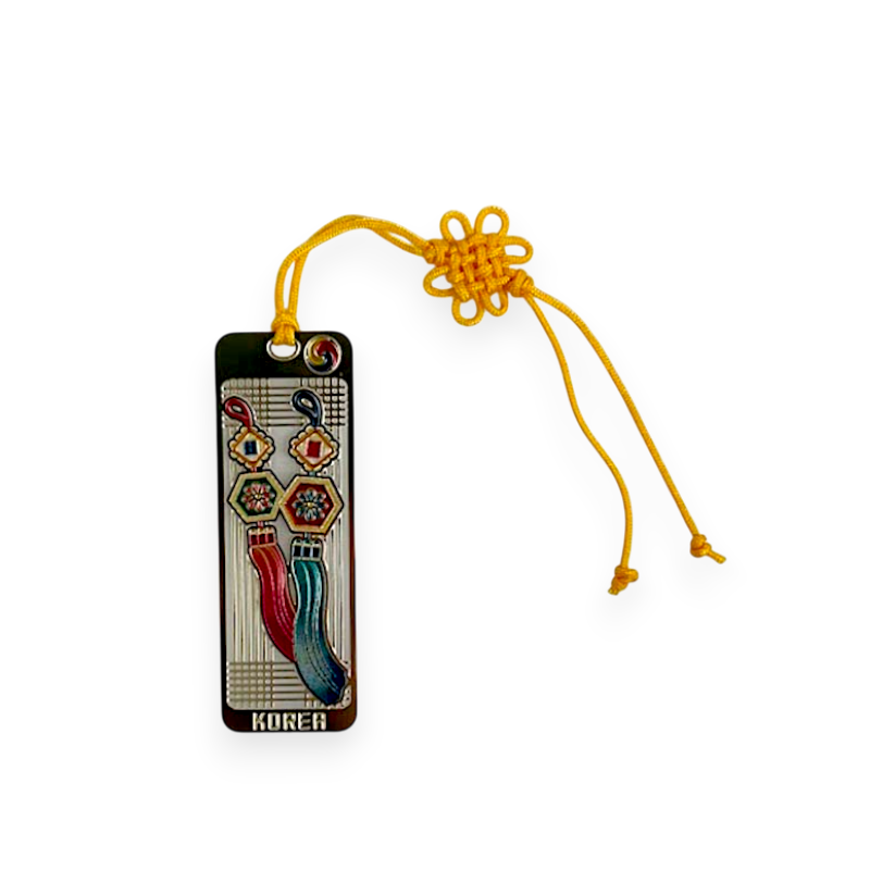 금속 재질에 붉은색·청색 노리개와 육각 꽃문양이 채색된 장식, 노란 전통 매듭 끈이 연결된 책갈피.