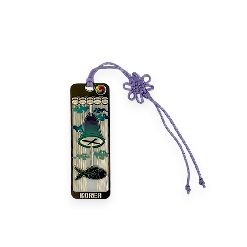 금속 재질 바탕에 청록색 풍경 종과 물고기 문양을 넣은 책갈피, 상단 태극 문양과 연보라색 전통 매듭 끈 장식.