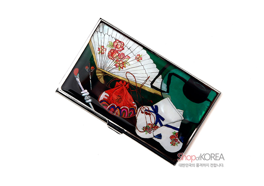 [텍스트: Shop of KOREA 대한민국의 품격까지 전합니다.] 광택 금속 명함집 위에 꽃무늬 부채, 전통 꽃버선과 복주머니, 비녀가 다채로운 색감으로 인쇄된 디자인