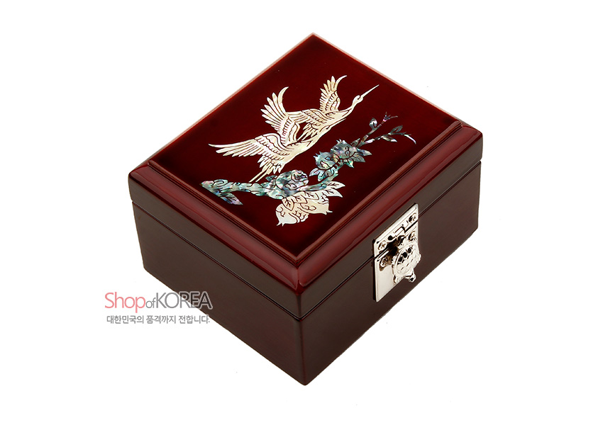 [텍스트: Shop of KOREA 대한민국의 품격까지 전합니다] 붉은 옻칠 사각함 위 자개 상감 기법의 쌍학과 꽃나무 문양, 은색 금속 잠금장치 장식 보석함 이미지 설명