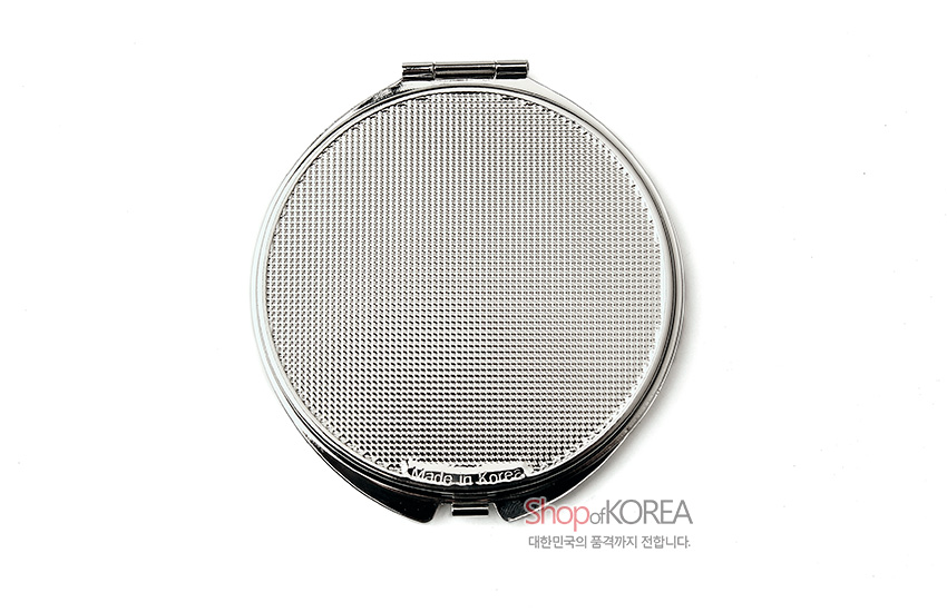 [텍스트: ShopofKOREA 대한민국의 품격까지 전합니다.] 촘촘한 점각 패턴이 새겨진 원형 금속 손거울 뒷면의 미세 질감 표현
