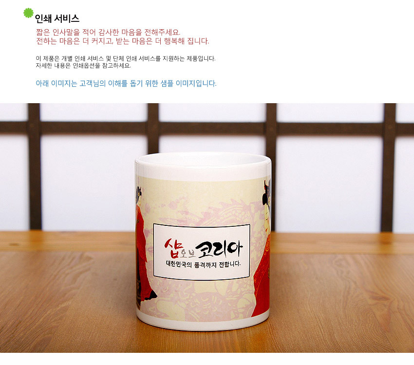 [텍스트: 인쇄 서비스 / 짧은 인사말을 적어 감사한 마음을 전해주세요. 전하는 마음은 더 커지고, 받는 마음은 더 행복해 집니다. / 아래 이미지는 고객님의 이해를 돕기 위한 샘플 이미지입니다. / 샵오브코리아 대한민국의 품격까지 전합니다.] 왕비 예복 일러스트와 옅은 황금색 전통 문양이 인쇄된 도자기 머그컵 디자인 이미지 설명