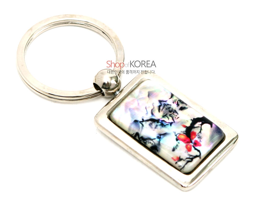 [텍스트: Shop of KOREA 대한민국의 품격까지 전합니다.] 금속 사각 테두리에 채색 자개를 상감해 산수도와 붉은 매화 가지를 표현한 열쇠고리 디자인