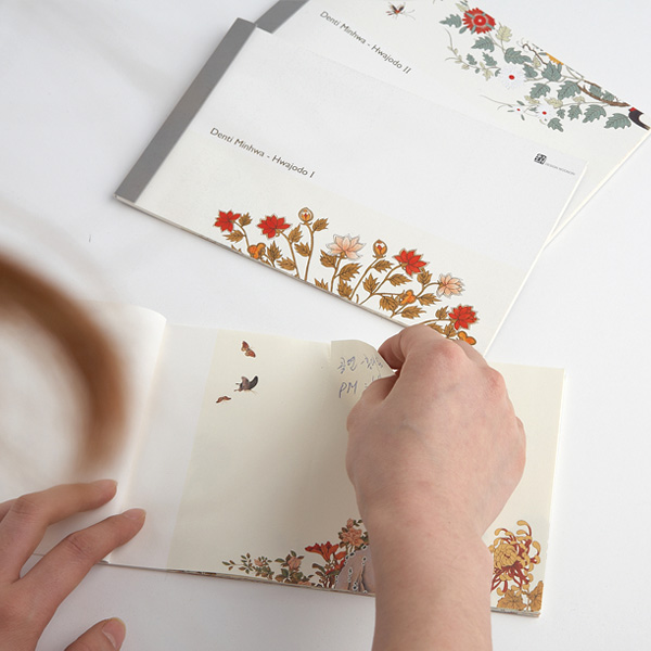 [텍스트: Damil Minhwa - Hwajodo 1] 연분홍빛 바탕 위 민화 화조도 문양, 붉은·흰 꽃과 황금빛 잎사귀, 새와 나비가 인쇄된 장방형 메모세트 디자인