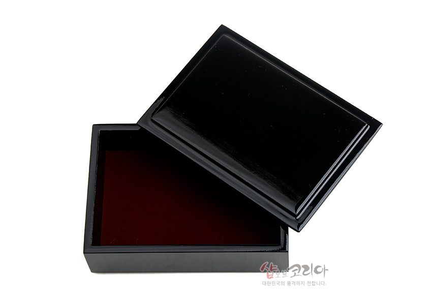 [텍스트: 샵오브코리아 대한민국의 품격까지 전합니다] 광택 있는 흑색 옻칠 외관과 짙은 적색 내부가 대비되는 직사각형 나전칠기 명함함 이미지 설명