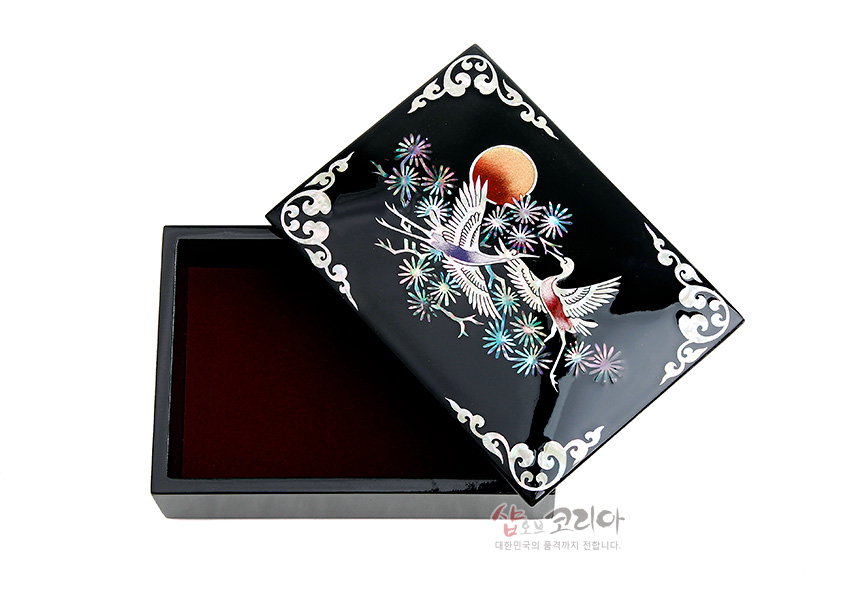 [텍스트: 샵오브코리아 대한민국의 품격까지 전합니다.] 흑색 옻칠 바탕 위 자개 상감 기법으로 송학과 소나무, 붉은 해를 채색한 직사각 나전칠기 명함함 디자인