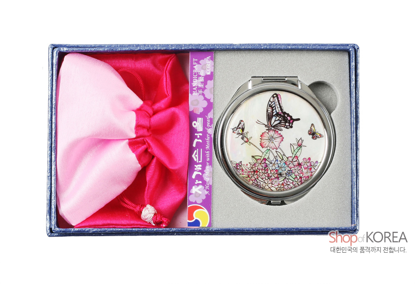 [텍스트: HANDICRAFT, Shop of KOREA 대한민국의 품격까지 전합니다.] 자개 상감 기법의 흰호랑나비·꽃 문양 원형 금속 손거울과 분홍·연분홍 비단 복주머니 세트 구성