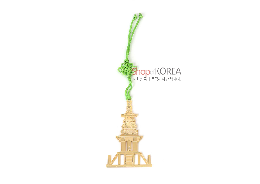 [텍스트: Shop of KOREA 대한민국의 품격까지 전합니다.] 금속 재질 금장으로 섬세하게 재현된 다보탑 형상의 책갈피와 연두색 전통 매듭 끈 장식 구성