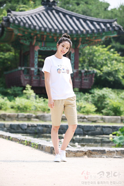 [텍스트: 샵오브코리아 대한민국의 품격까지 전합니다] 흰색 면 티셔츠에 태극기와 전통 탈, 한글 서체가 어우러진 컬러 3D 발포 프린트 장식, 배경 전통 정자와 조화된 야외 착용 연출 이미지