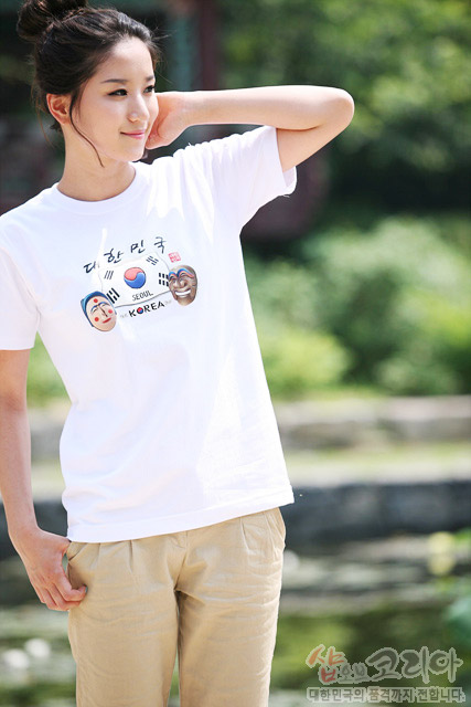 [텍스트: 대한민국 SEOUL KOREA] 흰색 면 티셔츠 위 태극기와 전통 탈, 한글 서체가 3D 발포 프린트로 표현된 입체 그래픽 구성