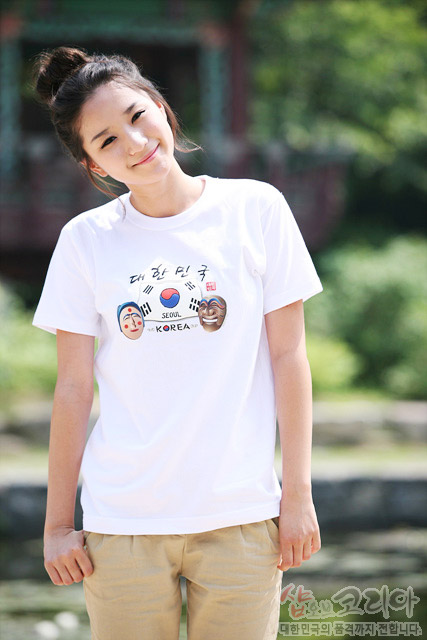 [텍스트: 대한민국 SEOUL KOREA] 흰색 면 티셔츠 중앙 태극기와 한글 서체, 양쪽 전통 탈과 하트 문양을 입체 발포 기법으로 컬러 프린트한 디자인