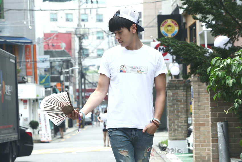 [텍스트: KOREA] 중앙 가로 패널에 혼례 한복 인물과 전통 문양을 3D 입체발포 기법으로 표현한 흰색 면 티셔츠 착용 모습