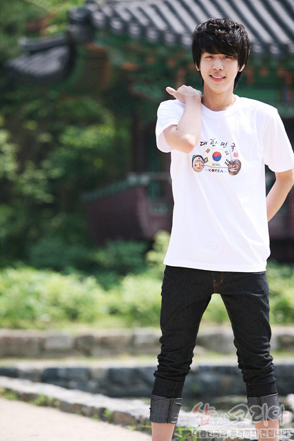 [텍스트: 대한민국 KOREA] 흰색 면 티셔츠 중앙 태극기와 전통 탈 문양, 한글 서체가 어우러진 컬러 3D 발포 프린트 디자인