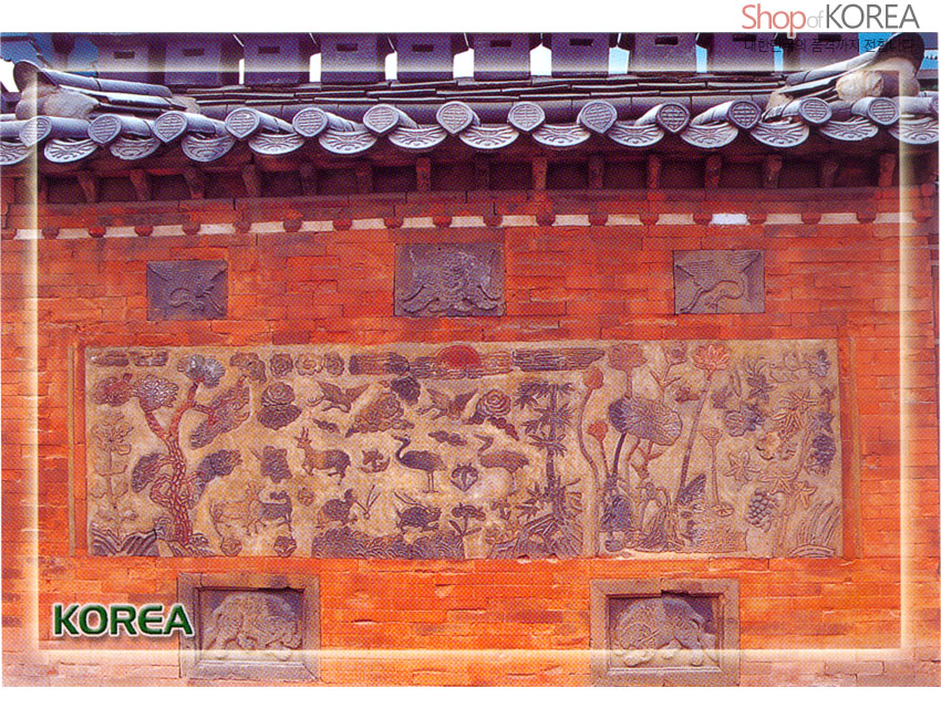 [텍스트: Shop of KOREA, KOREA] 붉은 벽돌 담장 위 석각 부조 장식, 학·사슴·연꽃·소나무 등 전통 길상문양과 회색 기와지붕 대비가 돋보이는 풍경엽서 디자인