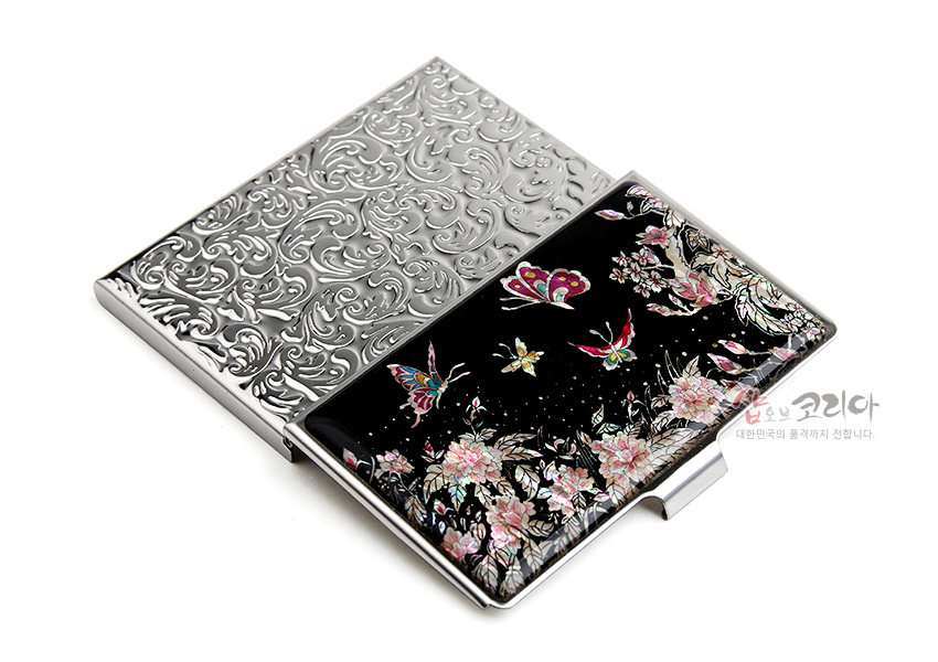 [텍스트: 샵오브코리아 대한민국의 품격까지 전합니다.] 흑색 옻칠 바탕 위 자개 상감으로 목단꽃과 다채로운 나비 문양을 장식한 금속 명함집 디자인
