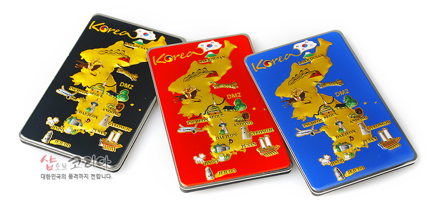 [텍스트: Korea, DMZ, INCHEON, SEOUL, ANDONG, DAEJON, KYONGJU, PUSAN, JEJUDO, SHOP OF KOREA, 대한민국의 품격까지 전합니다.] 금속 재질 입체 대한민국 지도를 금색으로 표현하고 검정·적색·청색 배경 위에 주요 관광지 아이콘을 다채롭게 장식한 자석 메모홀더 이미지 설명
