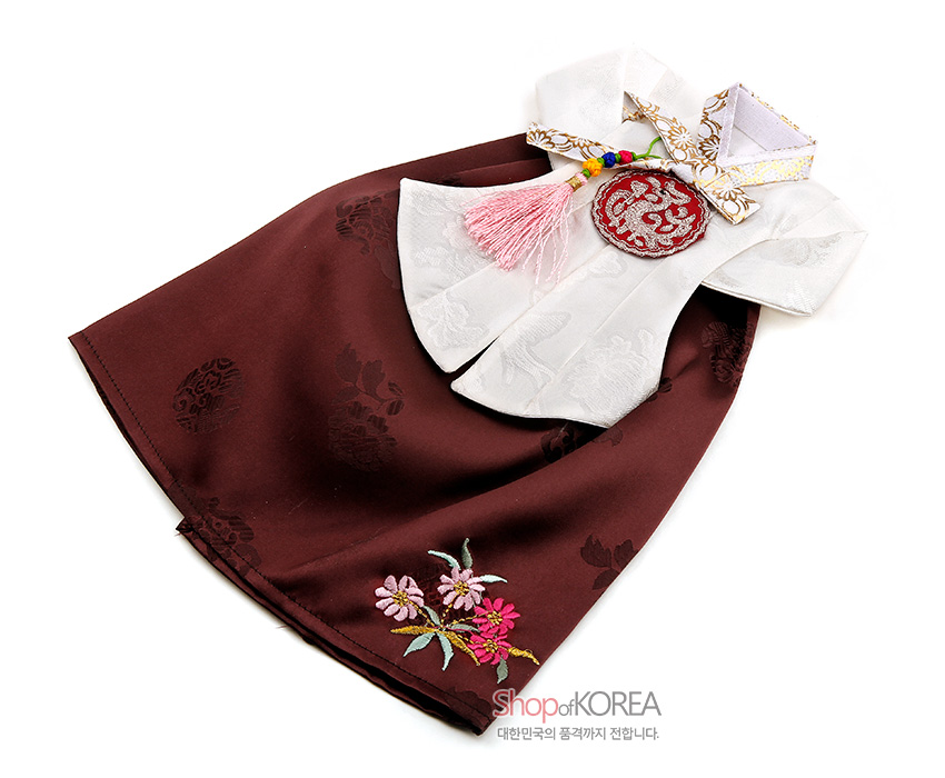 [텍스트: shopofKOREA 대한민국의 품격까지 전합니다.] 갈색 비단 치마와 백색 비단 저고리 조합, 수국·국화 자수와 전통 매듭 노리개 장식이 어우러진 당의형 와인커버 디자인