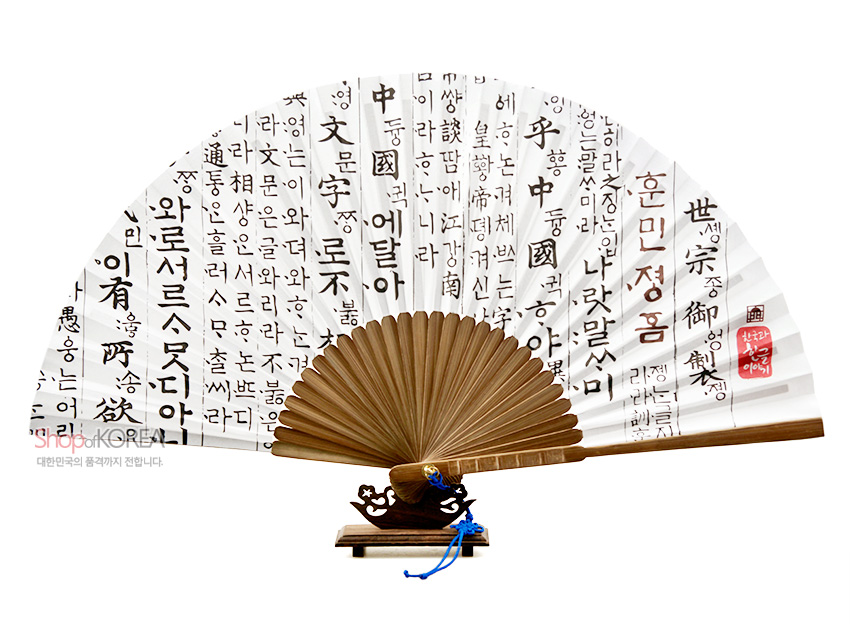 [텍스트: 훈민정음, 世宗御製, 나라말ᄊᆞ미, 中國에달아, 난중글이와로서르못디아니할ᄧ] 흰 한지 위 먹색 훈민정음 언해 서예문과 붉은 낙관, 대나무살과 청색 매듭 장식 전통 부채 모습