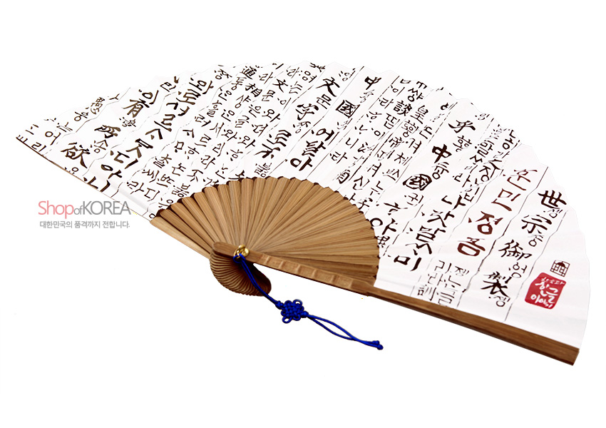 [텍스트: Shop of KOREA 대한민국의 품격까지 전합니다] 흰색 한지에 먹색 훈민정음 언해 서예문과 붉은 낙관이 인쇄된 접이식 부채, 자연색 대나무살과 청색 매듭 끈 장식 구성