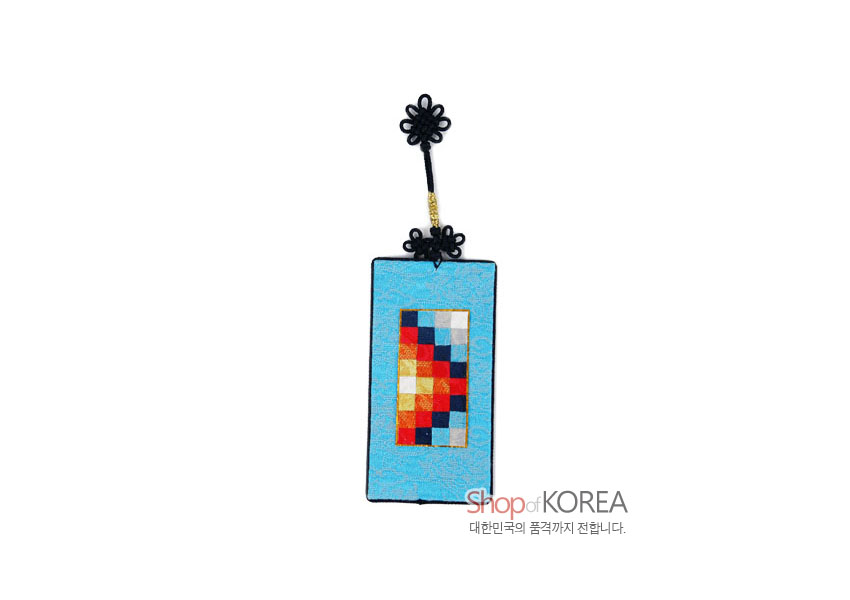 [텍스트: Shop of KOREA 대한민국의 품격까지 전합니다.] 하늘색 비단 바탕의 직사각형에 빨강·노랑·파랑·흰색 조각보 누비 문양과 검정 전통 매듭 장식이 어우러진 책갈피 형상