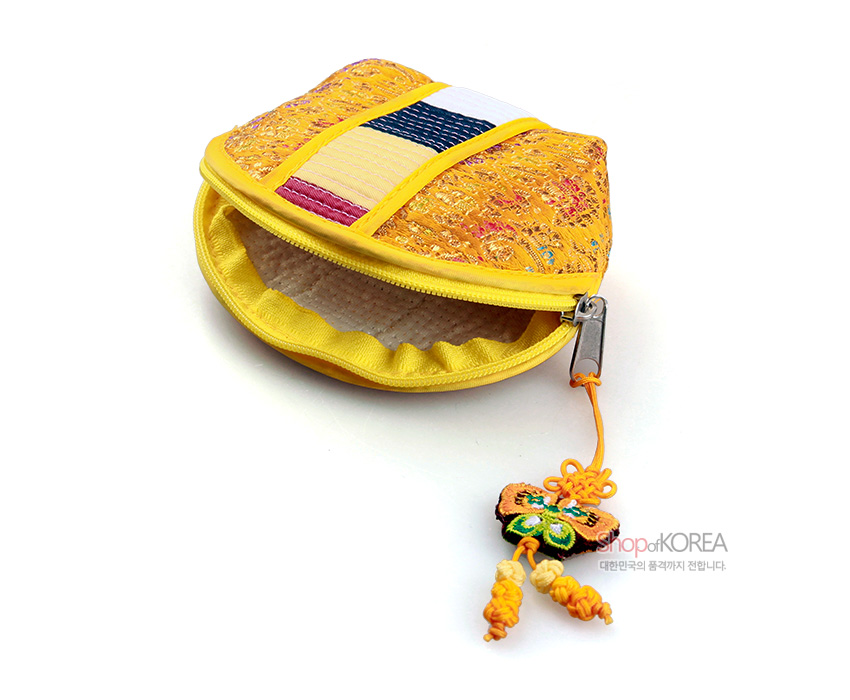 [텍스트: shopofKOREA 대한민국의 품격까지 전합니다.] 황색 비단 누비 바탕에 전통 꽃무늬 직조와 색동띠 장식, 나비 매듭 노리개 장식이 달린 반원형 동전지갑 이미지 설명