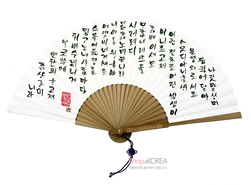 [텍스트: 나랏말싸미 듕귁에 달아 문자와로 서를 삼아도 못할셰 이셔도...] 흰 한지 위 먹빛 훈민정음 캘리그래피와 붉은 전각 인장, 대나무 살과 자주색 매듭 장식 조화 이미지