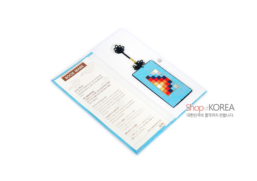 [텍스트: BOOK MARK, Shop of KOREA 대한민국의 품격까지 전합니다.] 하늘색 비단 직사각형 바탕에 다채로운 색 조각보 누비 문양과 검정 전통 매듭 장식이 어우러진 책갈피 이미지 설명