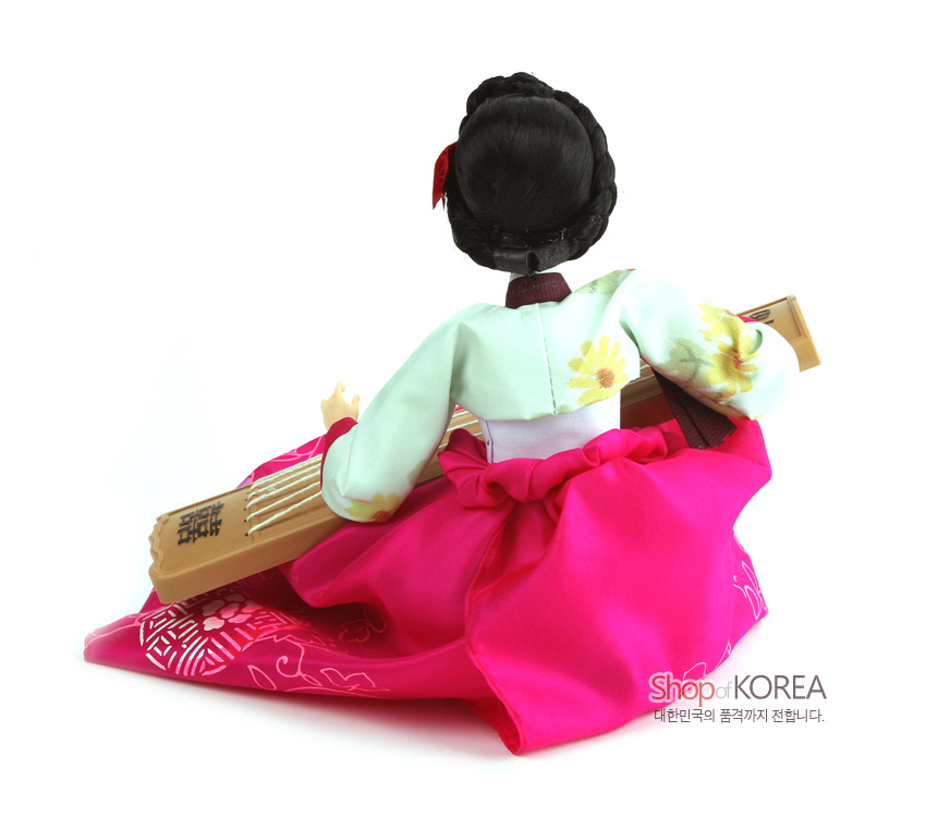 [텍스트: Shop of KOREA 대한민국의 품격까지 전합니다.] 분홍 꽃문양 비단 치마와 연두색 꽃자수 저고리를 입고 나무 재질 가야금을 연주하는 전통 한복 인형 뒷모습 장식