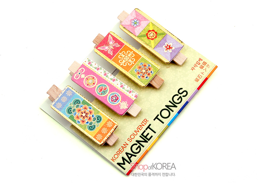 [텍스트: KOREAN SOUVENIR MAGNET TONGS / shop of KOREA / 거자석집게] 나무 집게 위 금속판에 전통 꽃·나비 문양과 원형 단청무늬를 파스텔 톤으로 인쇄한 자석 메모 집게 4P 세트 이미지 설명