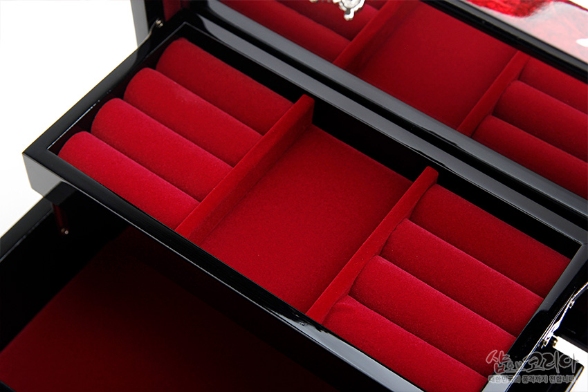 [텍스트: 샵오브코리아 한국의 전통과 문화를 전합니다] 붉은 벨벳 안감과 칸막이, 반지 정리용 롤 구조가 돋보이는 흑색 옻칠 한지 나전칠기 보석함 내부 디자인 이미지