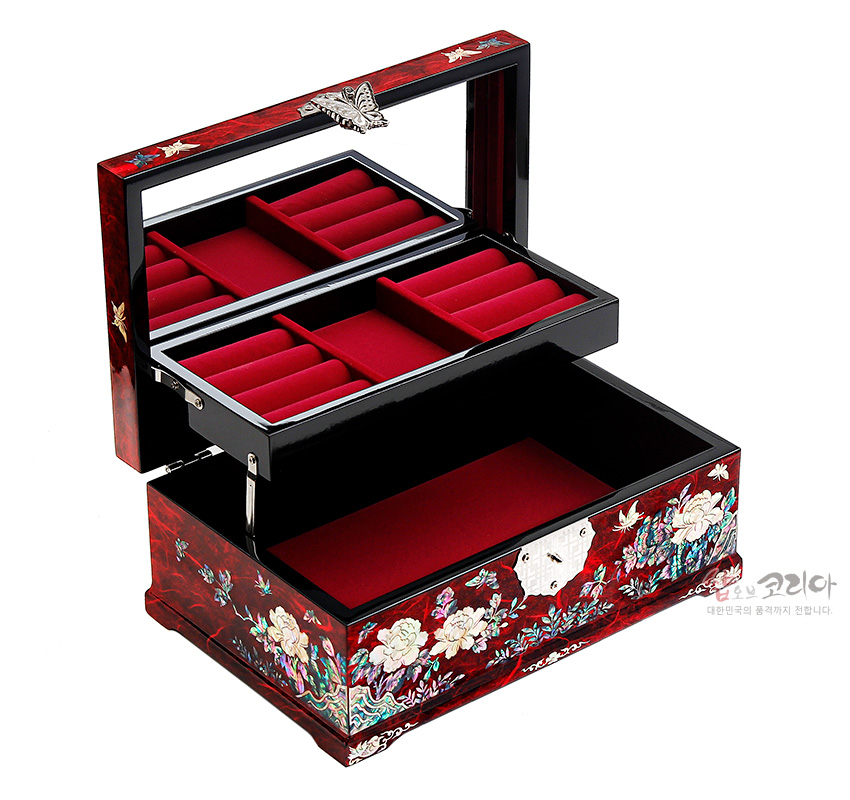 [텍스트: 샵오브코리아 대한민국의 혼과정까지 전합니다.] 붉은 옻칠 바탕 위 자개 상감 목단·나비 문양과 은색 금속 잠금장식, 내부 붉은 벨벳 칸막이로 구성된 직사각형 한지 나전칠기 보석함 이미지 설명