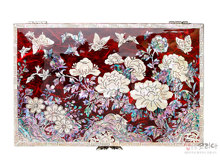 [텍스트: 샵오브코리아 대한민국의 품격까지 전해집니다.] 붉은 옻칠 한지 바탕 위에 자개 상감 기법으로 목단과 나비, 구름 문양을 섬세하게 장식한 직사각형 보석함 디자인