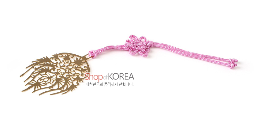 [텍스트: Shop of KOREA 대한민국의 품격까지 전합니다.] 금장 금속 재질에 섬세한 투각으로 왕비관과 연화 덩굴 문양을 표현하고 분홍색 전통 매듭 끈을 더한 책갈피 디자인