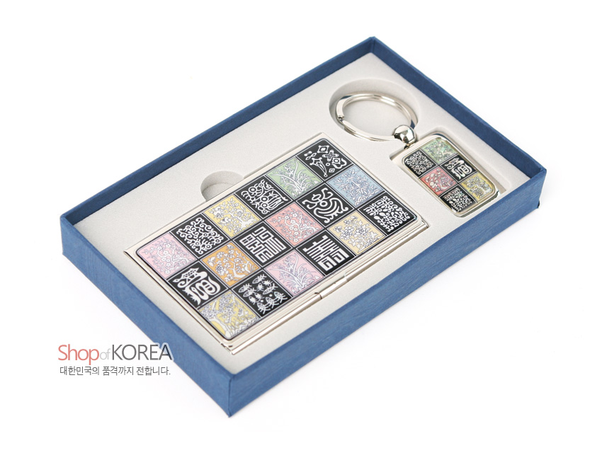 [텍스트: Shop of KOREA 대한민국의 품격까지 전합니다.] 금속 재질 위 자개 채색으로 사각 격자 안에 전서체 길상문과 식물 문양을 배치한 명함집과 열쇠고리 세트 이미지 설명