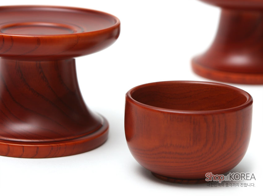 [텍스트: ShopKOREA 대한민국의 품격까지 전합니다.] 붉은 갈색 옻칠 마감의 물푸레나무 제기, 나뭇결이 살아 있는 곡선형 받침과 소반, 단정한 반구형 그릇 구성