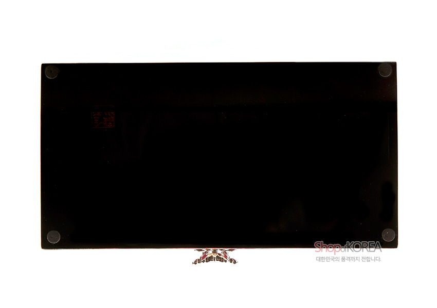 [텍스트: ShopKOREA 대한민국의 감각까지 전합니다.] 사각형 한지 보석함 바닥면의 광택 있는 흑색 옻칠 처리와 모서리의 원형 보호 패드, 중앙 자개 장식 다리 디테일 표현