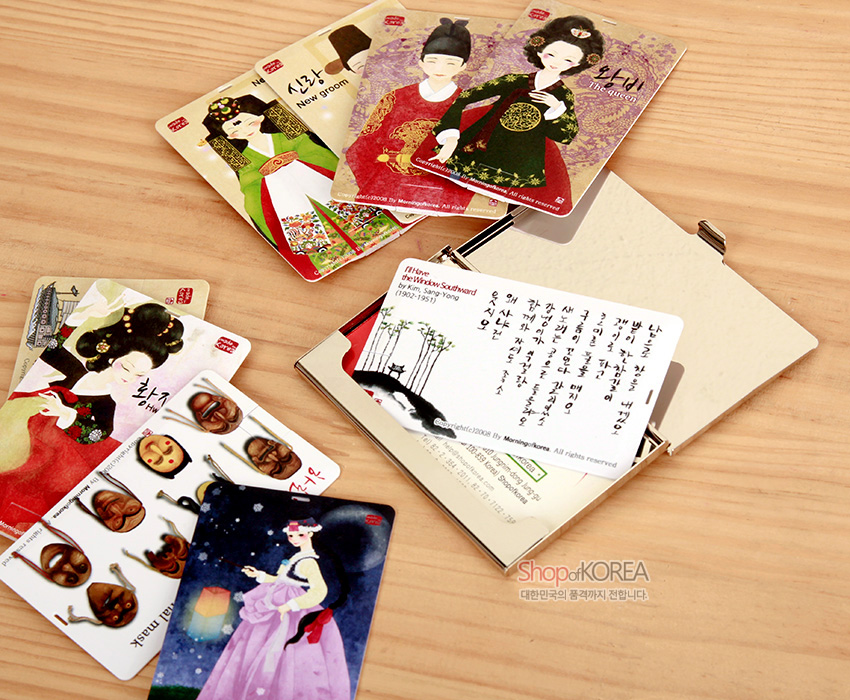 [텍스트: New groom / The queen / Hwang jin yi / Hahoe mask / I love the Wind in South ward 등] 곤룡포와 원삼, 가채 머리 장식, 하회탈과 한글 서예가 그려진 카드형 USB 여러 장이 나무 배경 위에 펼쳐진 구성