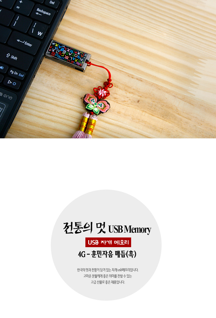 [텍스트: 전통의 멋 USB Memory / USB 자개 메모리 / 4G-훈민자음 매듭(흑)] 흑색 바탕 금속 USB 본체에 다채로운 훈민정음 자모 문양 상감, 붉은 끈과 나비 자수 비단매듭·분홍 술 장식 구성 이미지