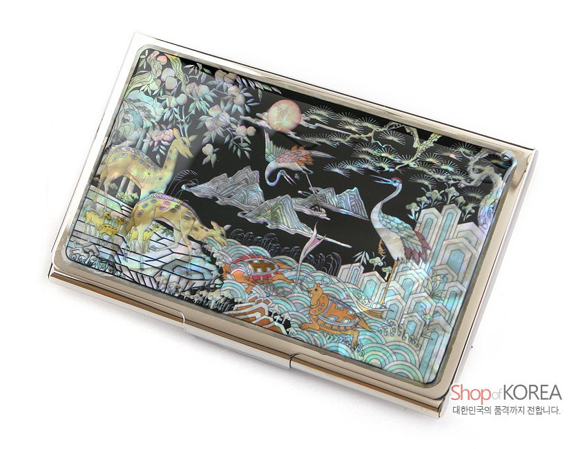 [텍스트: Shop of KOREA 대한민국의 품격까지 전합니다.] 흑색 옻칠 바탕에 자개 상감 기법으로 학·사슴·거북·산·해·파도 등 십장생 문양을 정교하게 표현한 금속 명함집 디자인