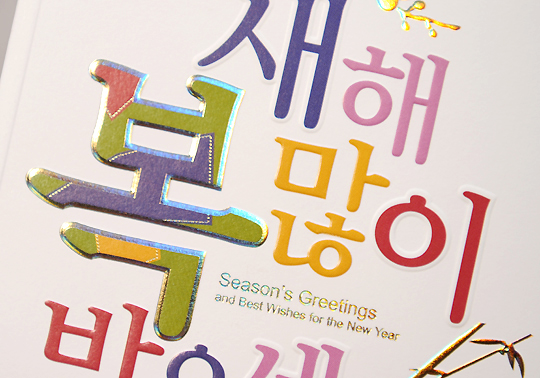 [텍스트: 새해 복 많이 받으세요 / Season’s Greetings and Best Wishes for the New Year] 형형색색 홀로그램 서체와 금박 포인트가 돋보이는 새해 연하장 디자인