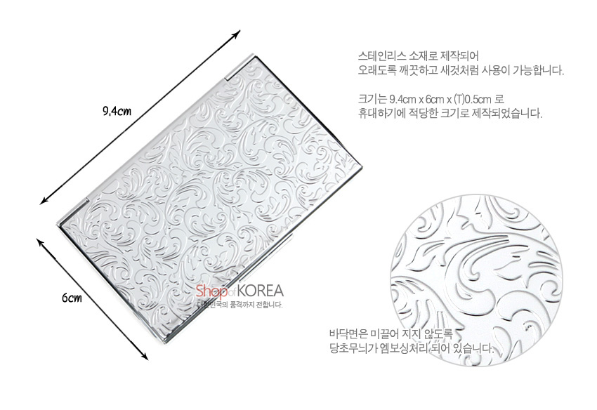[텍스트: 9.4cm, 6cm, Shop of KOREA, 스테인리스 소재로 제작되어 오래도록 깨끗하고 새것처럼 사용이 가능합니다. 크기는 9.4cm x 6cm x (T)0.5cm 로 휴대하기에 적당한 크기로 제작되었습니다. 바닥면은 미끌어 지지 않도록 당초무늬가 엠보싱처리되어 있습니다.] 스테인리스 재질 명함집, 은색 당초문 엠보싱 장식과 직사각형 슬림 디자인 특징 이미지 설명