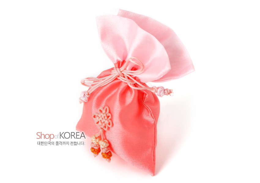 [텍스트: Shop of KOREA / 대한민국의 품격까지 전합니다.] 담주색 계열 비단 소재 복주머니, 분홍빛 전통 매듭과 다색 매듭 술 장식이 돋보이는 매듭주머니 이미지 설명