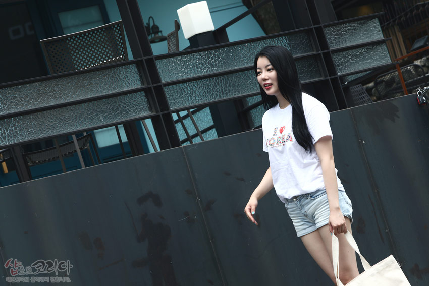 [텍스트: I ♥ KOREA] 흰색 면 티셔츠 전면에 다채로운 전통 패턴을 활용한 영문 문구를 3D 입체발포 기법으로 표현한 반팔 디자인