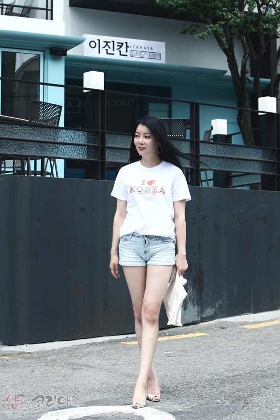 [텍스트: I ♥ KOREA, 이진칸 IZAKAYA] 흰색 면 반팔 티셔츠에 3D 입체발포 기법으로 표현된 ‘I ♥ KOREA’ 문구와 다채로운 전통 패턴 문양 장식 이미지 설명