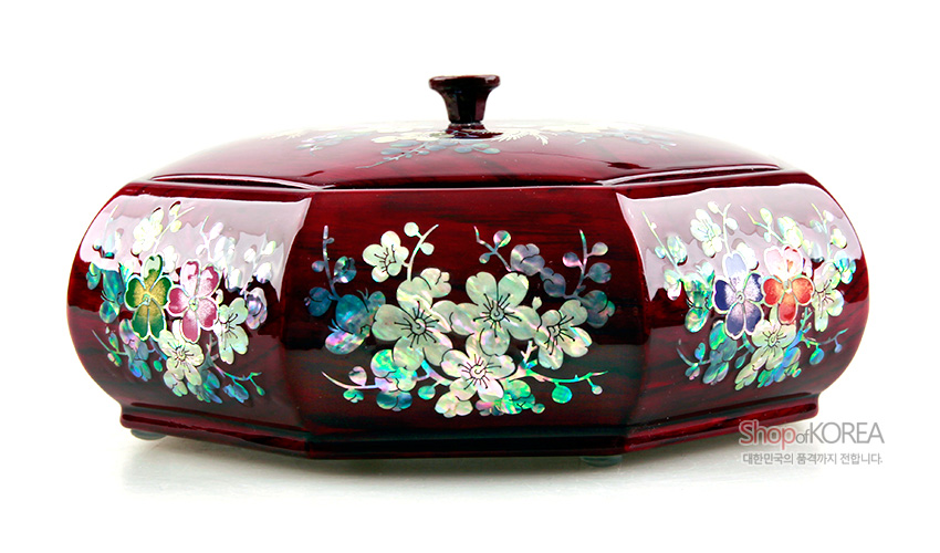 [텍스트: Shop of KOREA 대한민국의 품격까지 전합니다.] 붉은 옻칠 바탕 팔각 주합 위 자개 상감 매화와 화조문이 다채로운 색감으로 장식된 나전칠기 다용도함 이미지 설명