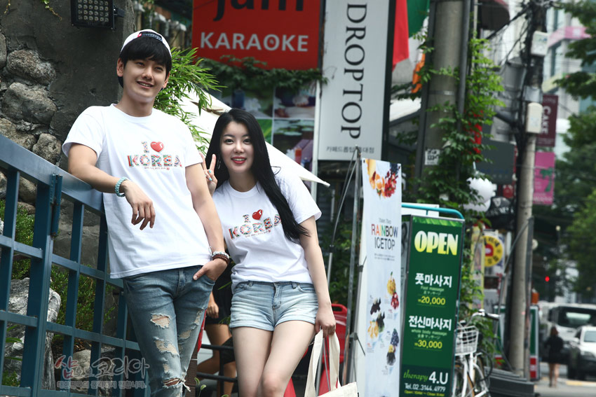 [텍스트: I ♥ KOREA] 흰색 면 티셔츠에 3D 입체발포 기법으로 표현된 하트와 영문 문구, 오방색 전통 패턴 장식이 돋보이는 캐주얼 반팔 티셔츠 연출 이미지